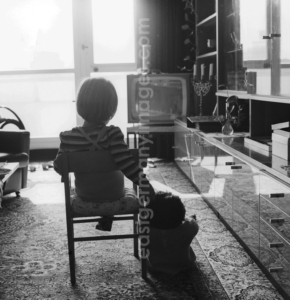 GDR picture archive: Berlin - Small child sitting in front of the TV in the living room in Berlin