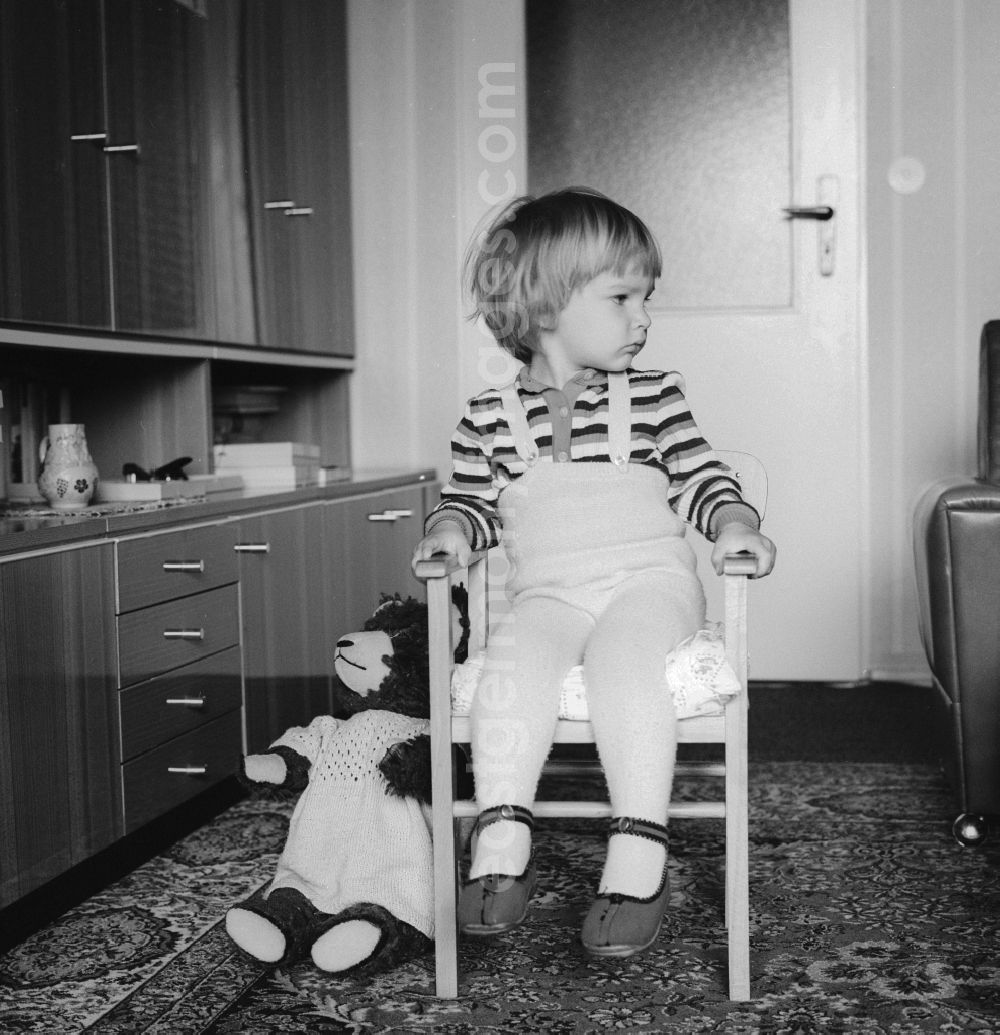 GDR image archive: Berlin - Cute little baby sitting dreamily on a chair in Berlin