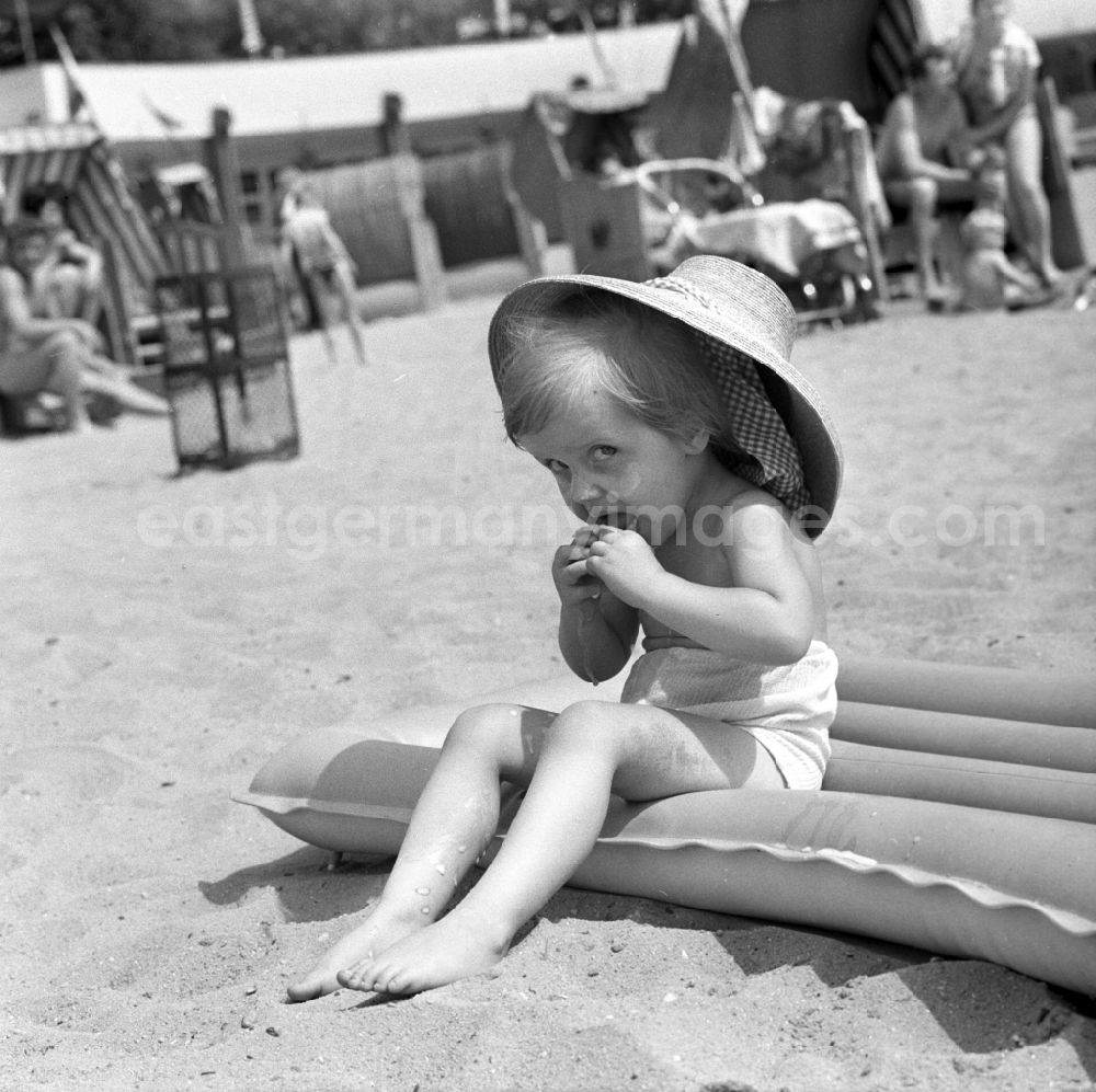 GDR photo archive: Berlin - Köpenick - A small child with straw hat on an air mattress in the beach Müggelsee in Berlin - Köpenick. The lido Müggelsee, also known as beach Rahn village is a swimming pool in Berlin-Rahn village on the north bank of the Müggelsee