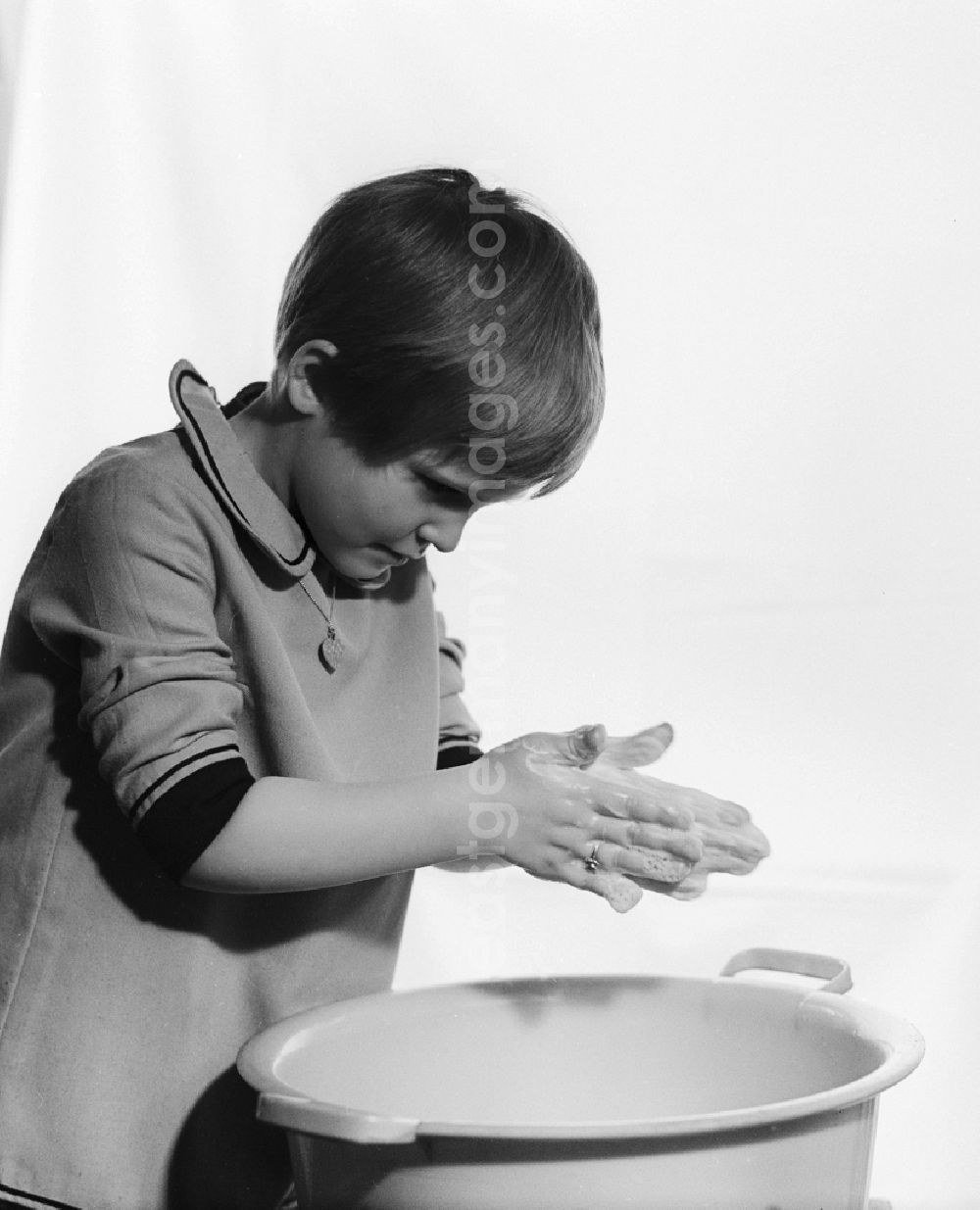 GDR picture archive: Berlin - Small girl washing hands over a plastic bowl in Berlin
