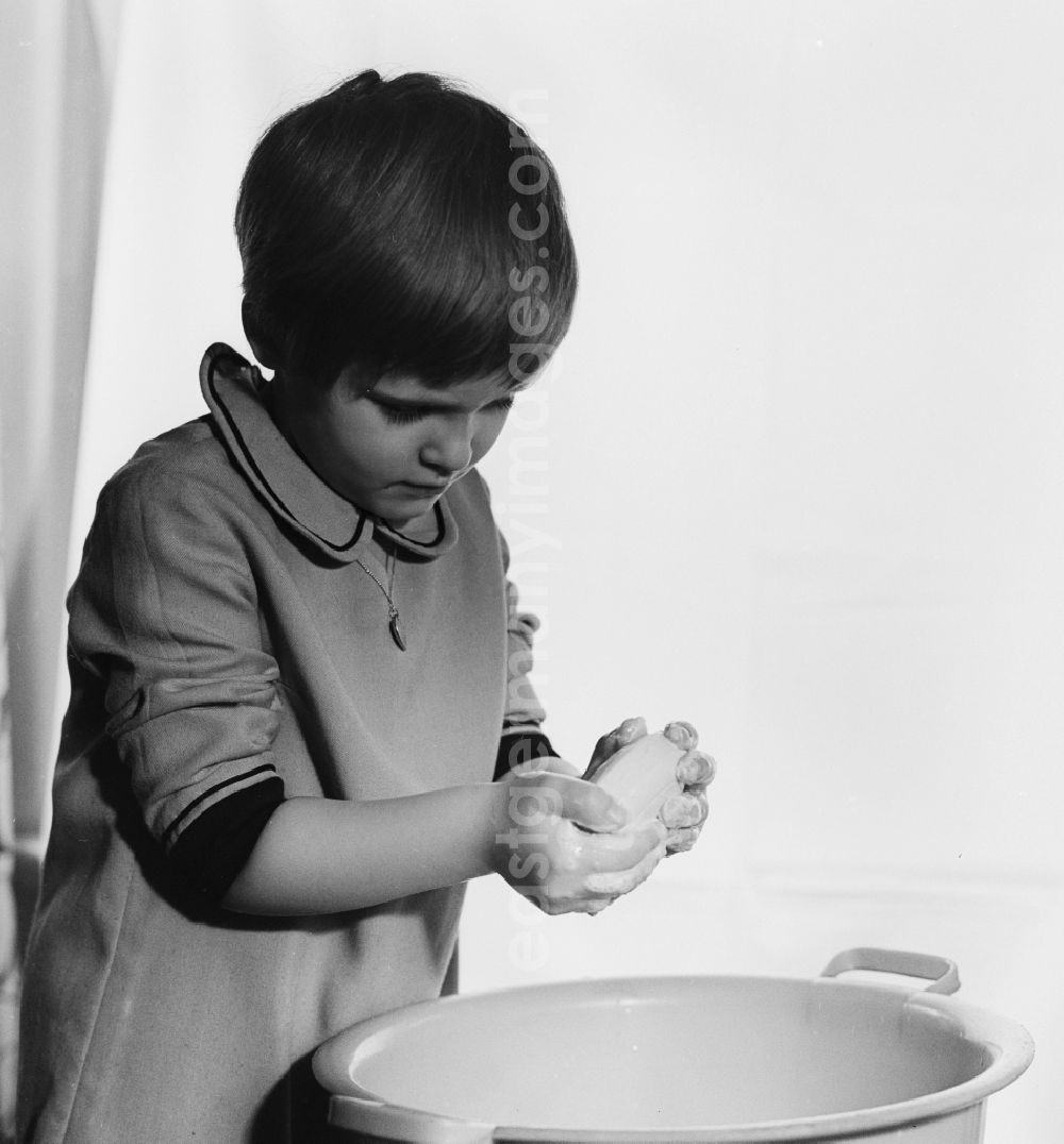 GDR image archive: Berlin - Small girl washing hands over a plastic bowl in Berlin