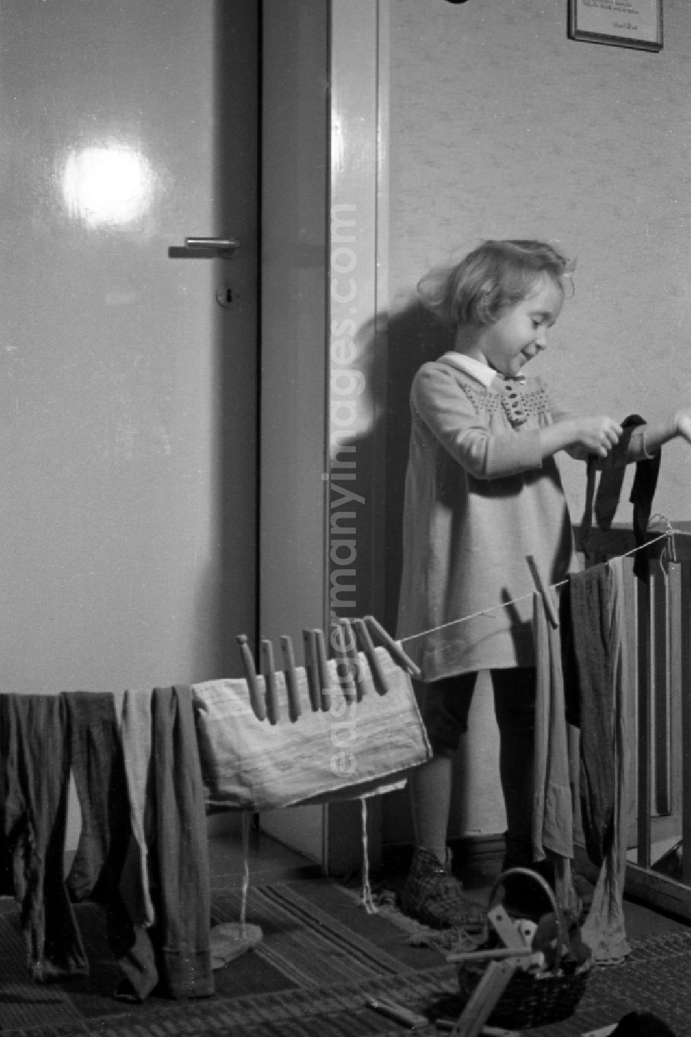 GDR photo archive: Merseburg - A small girl plays laundry hang up in Merseburg in the federal state Saxony-Anhalt in Germany