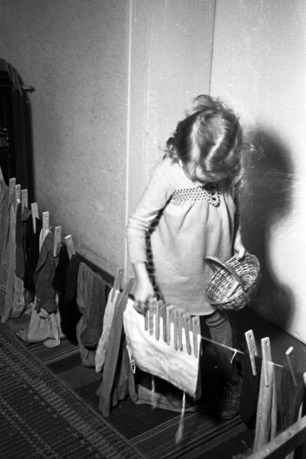 GDR picture archive: Merseburg - A small girl plays laundry hang up in Merseburg in the federal state Saxony-Anhalt in Germany