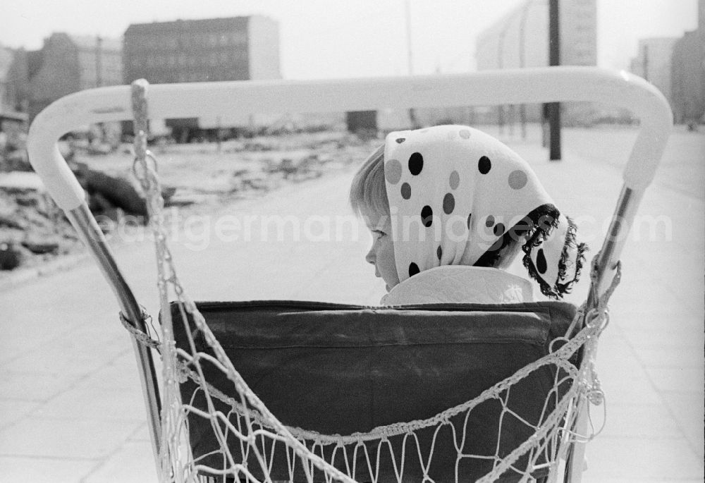 GDR image archive: Berlin - A little girl with a headscarf sits in a pram in Berlin, the former capital of the GDR, German Democratic Republic