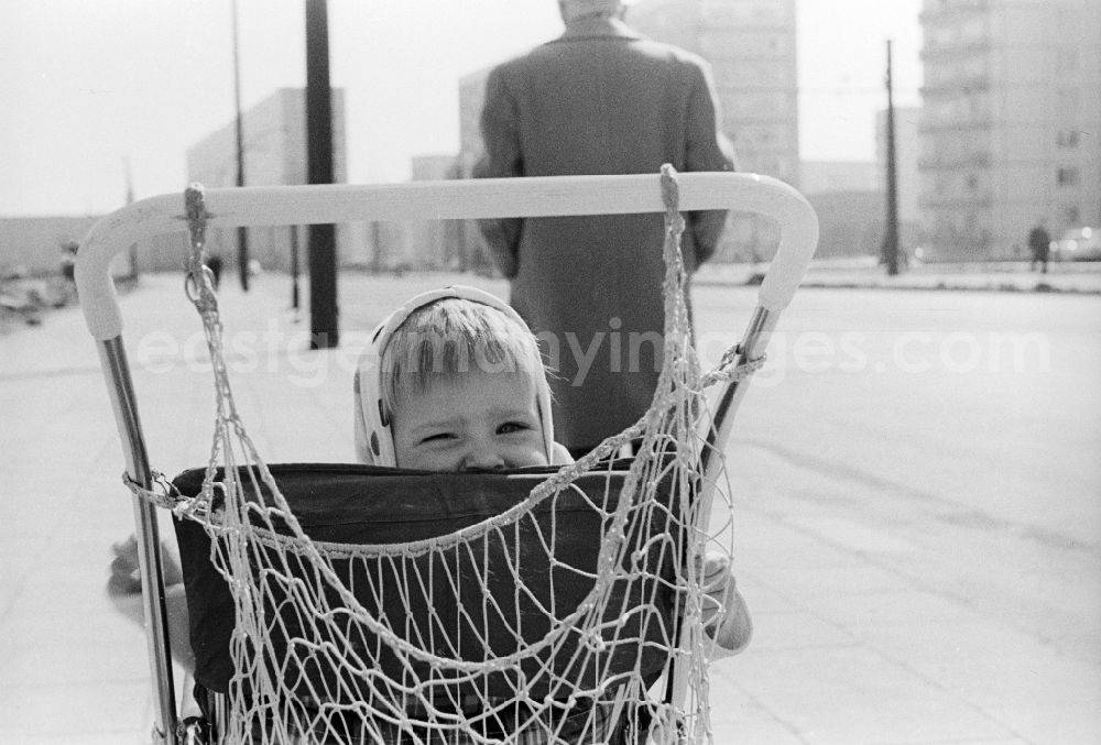 GDR photo archive: Berlin - A little girl with a headscarf sits in a pram in Berlin, the former capital of the GDR, German Democratic Republic