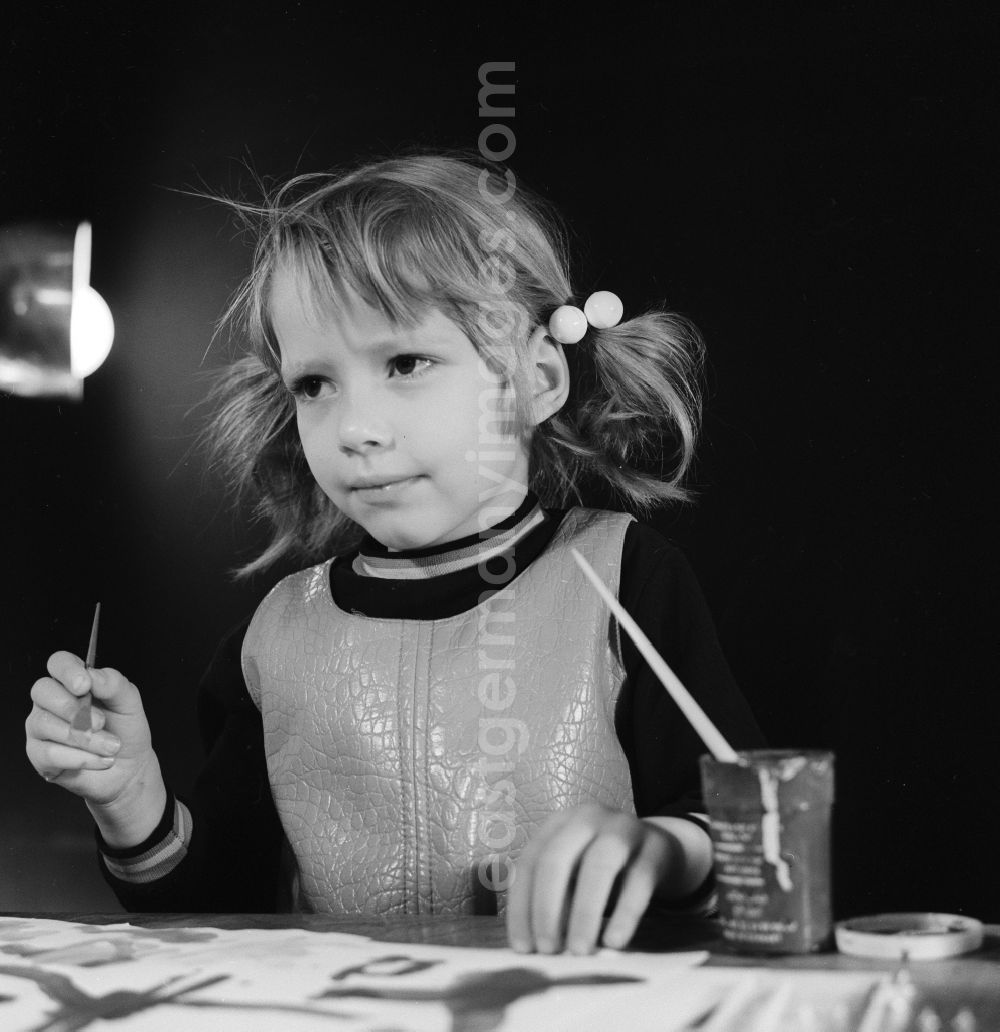 GDR image archive: Berlin - A little girl with pigtails painting with brush and ink in Berlin, the former capital of the GDR, German Democratic Republic