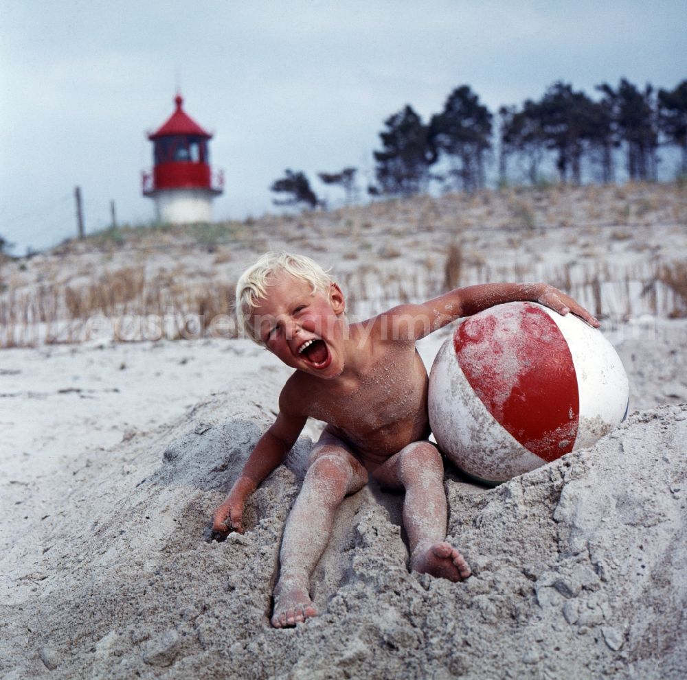 GDR picture archive: Rostock - Toddler with red and white beach ball on Warnemuende Beach in Rostock, Mecklenburg-Western Pomerania in the area of the former GDR, German Democratic Republic