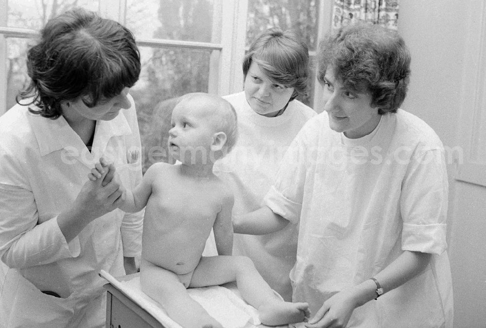 GDR image archive: Berlin - A girl is weighed by nurses of the clinic for paediatrics and youth medicine lime court in Berlin, the former capital of the GDR, German democratic republic. The children - hospital Lindenhof are a component of the Sana medical centres in the Berlin district bright mountain