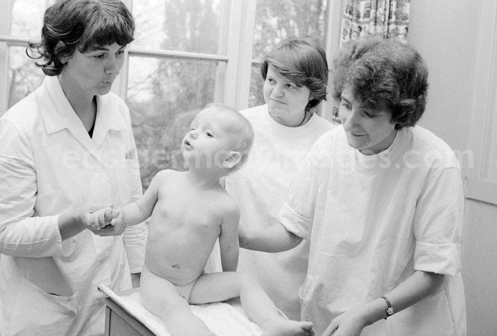 GDR photo archive: Berlin - A girl is weighed by nurses of the clinic for paediatrics and youth medicine lime court in Berlin, the former capital of the GDR, German democratic republic. The children - hospital Lindenhof are a component of the Sana medical centres in the Berlin district bright mountain