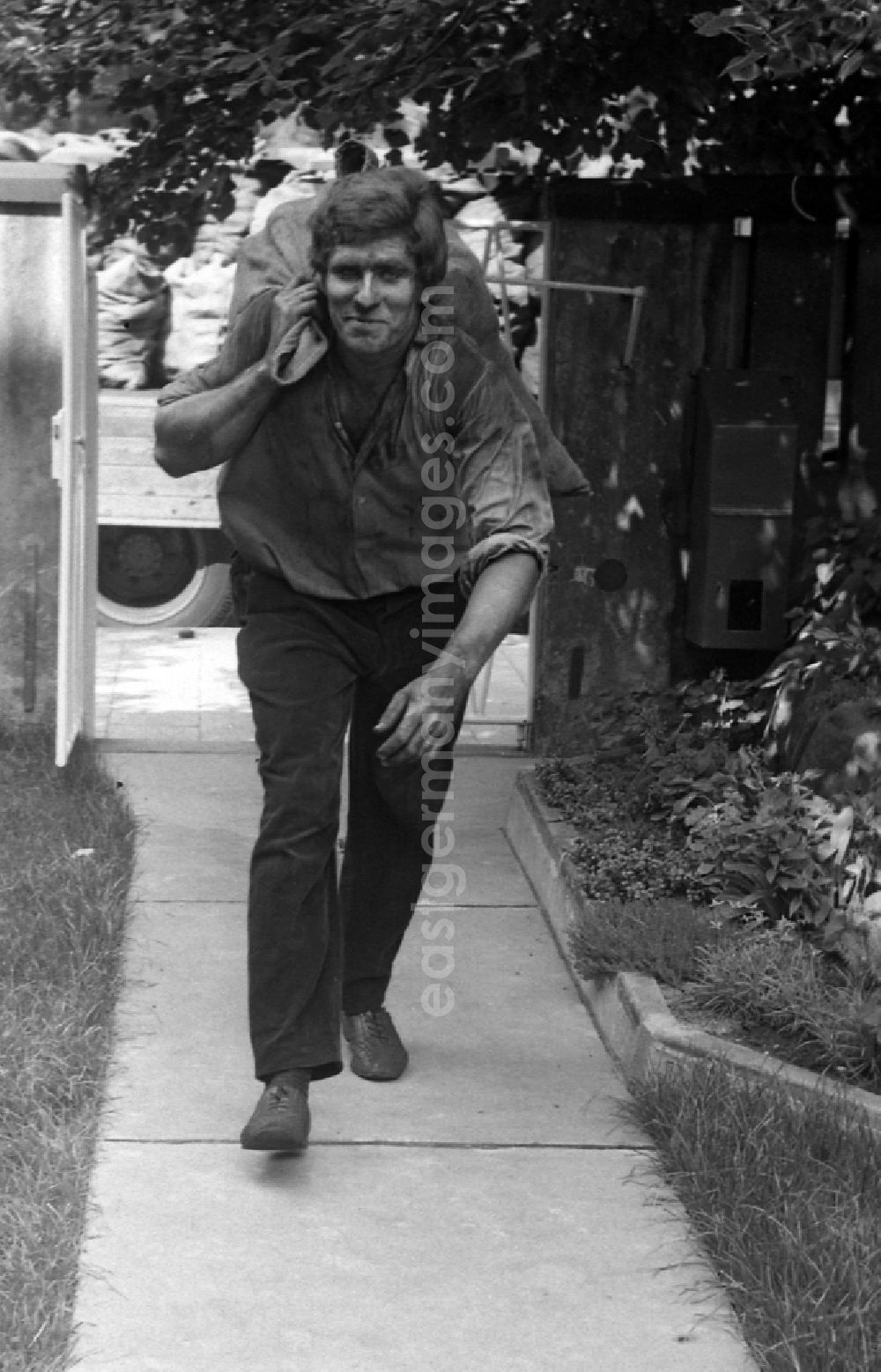GDR picture archive: Berlin - Worker carries a sack of carbon in the district Mitte in Berlin Eastberlin on the territory of the former GDR, German Democratic Republic