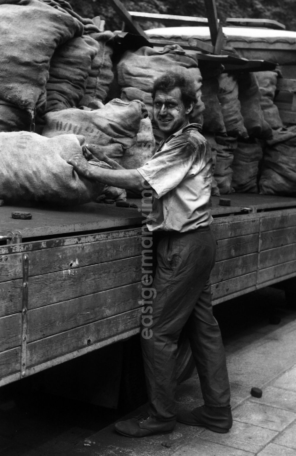 GDR photo archive: Berlin - Worker carries a sack of carbon in the district Mitte in Berlin Eastberlin on the territory of the former GDR, German Democratic Republic