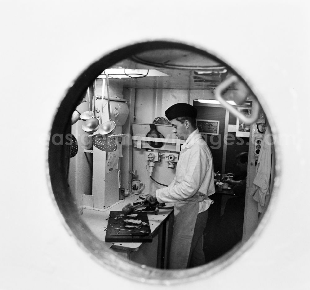 Peenemünde: View through a round porthole onto the workplace of a mate in the galley - galley of a landing ship of the People's Navy of the NVA National People's Army in Peenemuende in the state of Mecklenburg-Western Pomerania in the area of the former GDR, German Democratic Republic