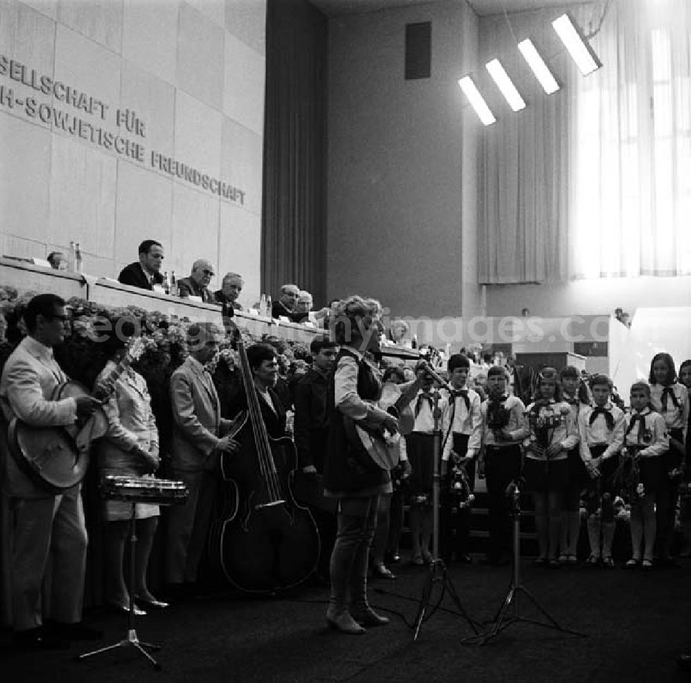 GDR picture archive: Berlin - Fahnenappell und Fahnenübergabe durch militärische Vertreter in der Werner - Seelenbinder - Halle. Umgeben von Pionieren spielt eine Musikgruppe vor dem Podium.