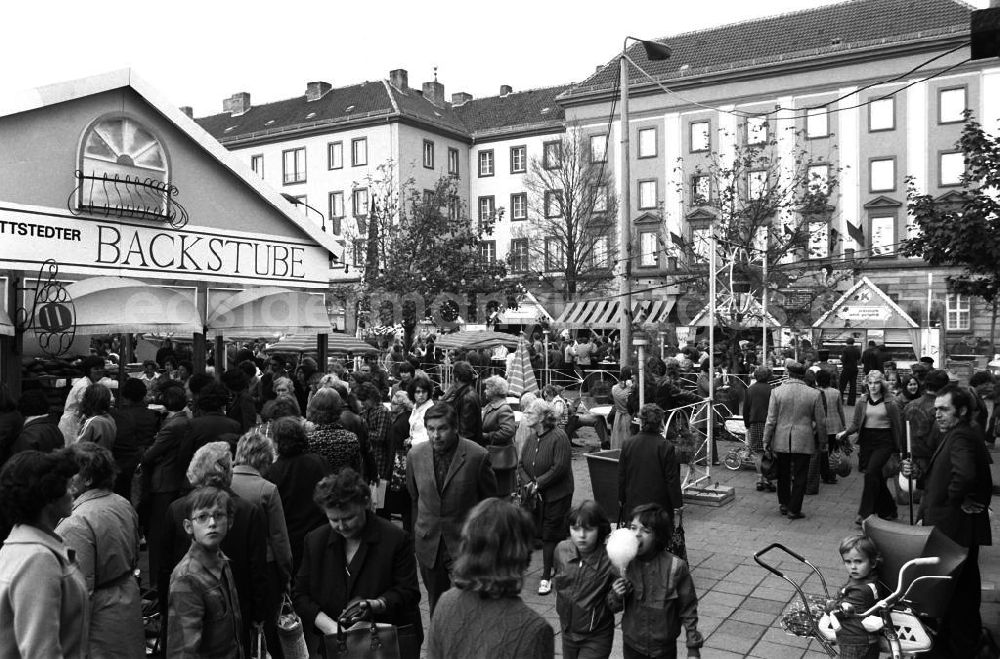 Merseburg: Blick auf den gut besuchten Konsum Markt in Merseburg. Passanten stehen am Stand einer Backstub (l), rechts steht ein Kind neben einem Kinderwagen.