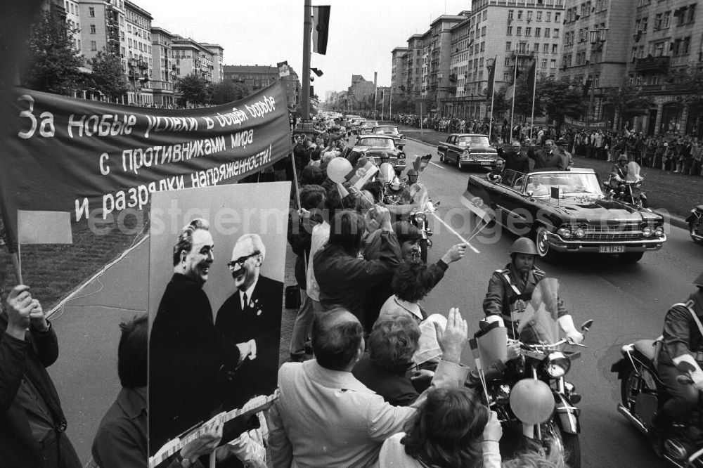 GDR image archive: Berlin - Leonid Iljitsch Breschnew während seines Staatsbesuch in der DDR. Breschnew und Erich Honecker im Autokonvoi winken aus fahrendem Auto auf der Frankfurter Allee, vorbei an Schaulustigen am Straßenrand.
