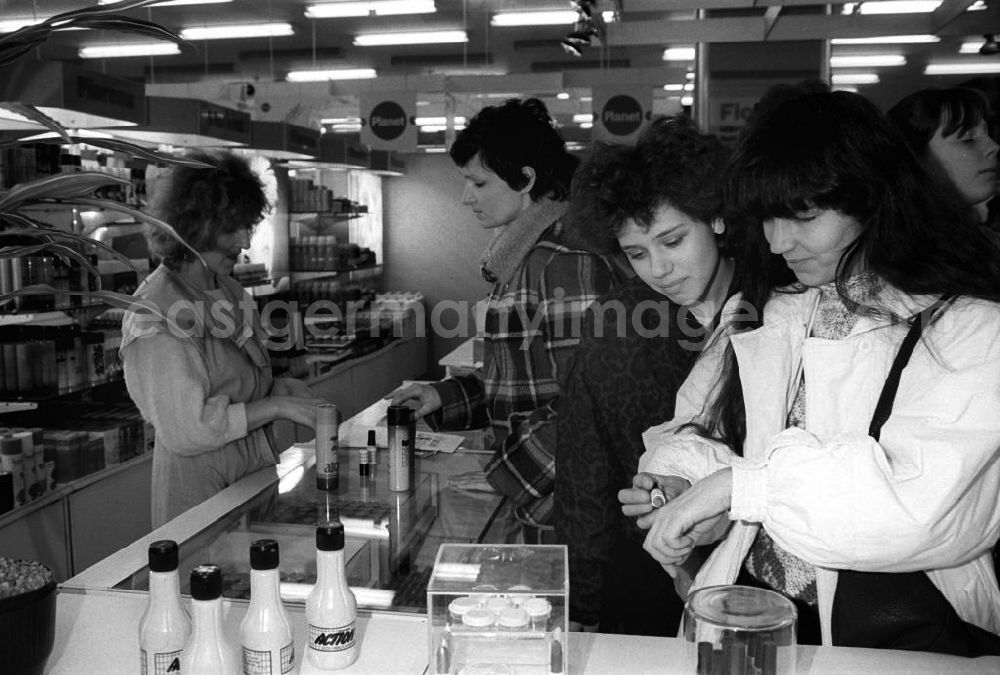 GDR photo archive: Berlin - Frauen stehen am Verkaufstresen und testen in der Kosmetikabteilung vom Centrum-Warenhaus am Alexanderplatz Kosmetikprodukte. Im Hintergrund berät eine Verkäuferin eine Kundin.