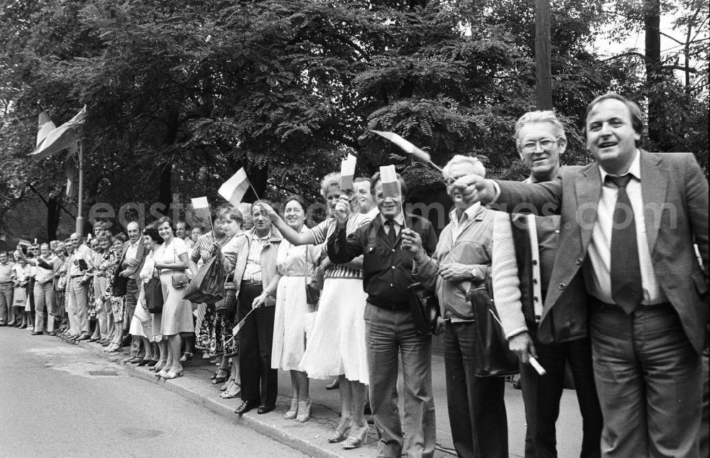 GDR photo archive: Krakau - Staatsbesuch von Erich Honecker, Staatsratsvorsitzender DDR, in der Volksrepublik Polen. Krakauer Bürger / Zuschauer / Schaulustige stehen am Strassenrand und winken mit Fahnen / Fähnchen / Flagge Polen.