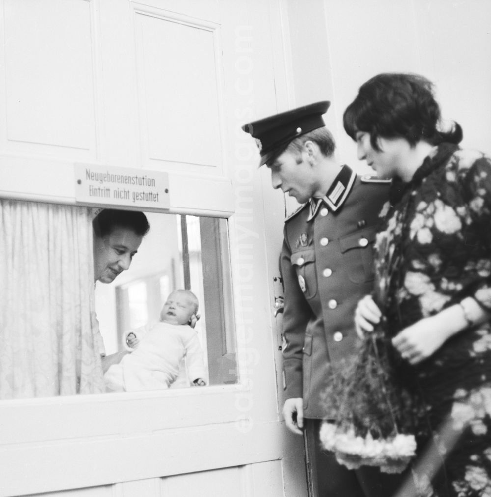 GDR photo archive: Berlin - Nurse showing young parents their baby through glass at the neonatal unit in Berlin