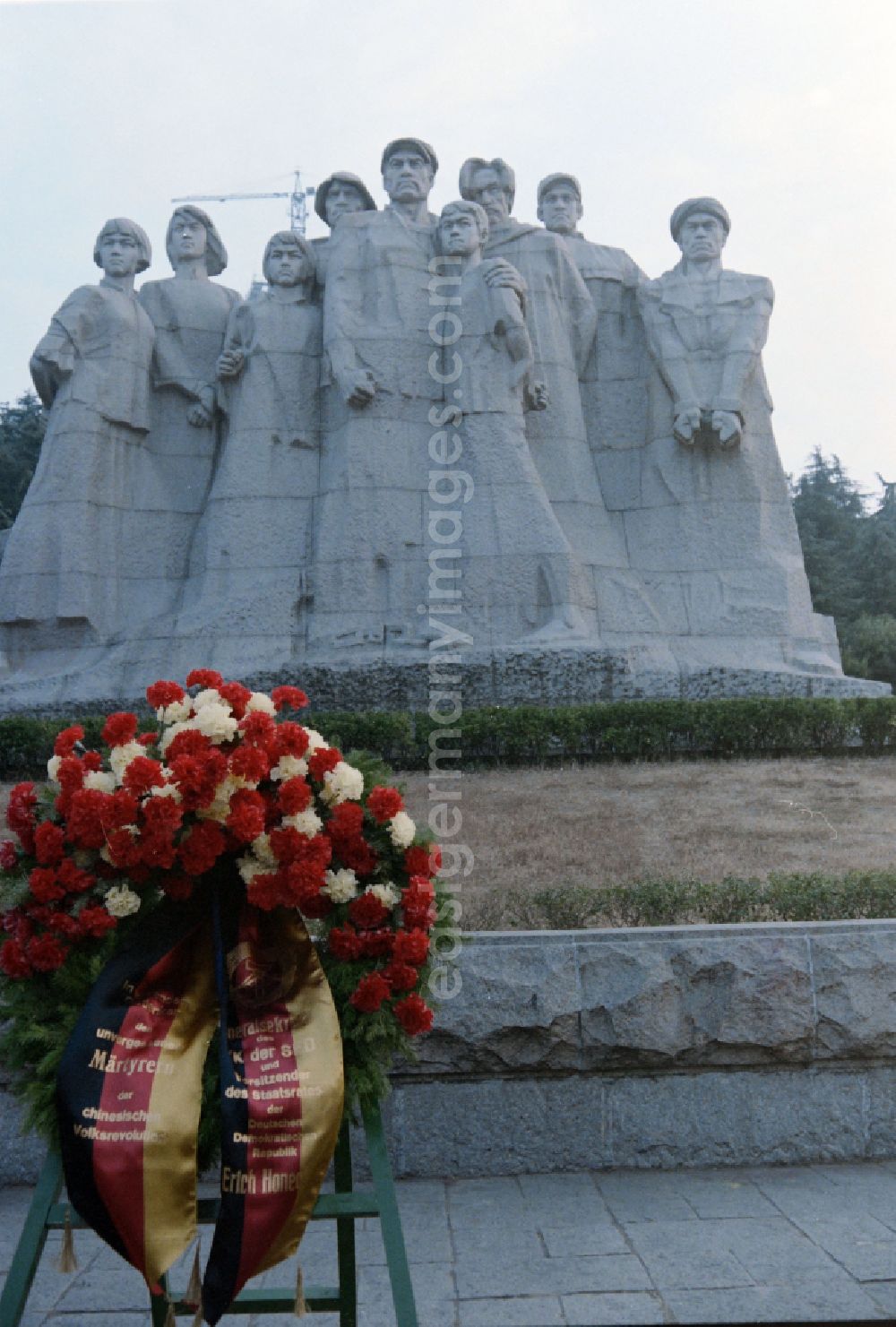 GDR picture archive: Nanjing - Participants of the official government delegation of the GDR under the General Secretary of the SED and Chairman of the State Council of the GDR Erich Honecker at the memorial statues of the Yuhuatai Martyrs in the Memorial Park of the Revolutionary Martyrs of the Chinese People's Revolution in the Yuhuatai district of Nanjing in China