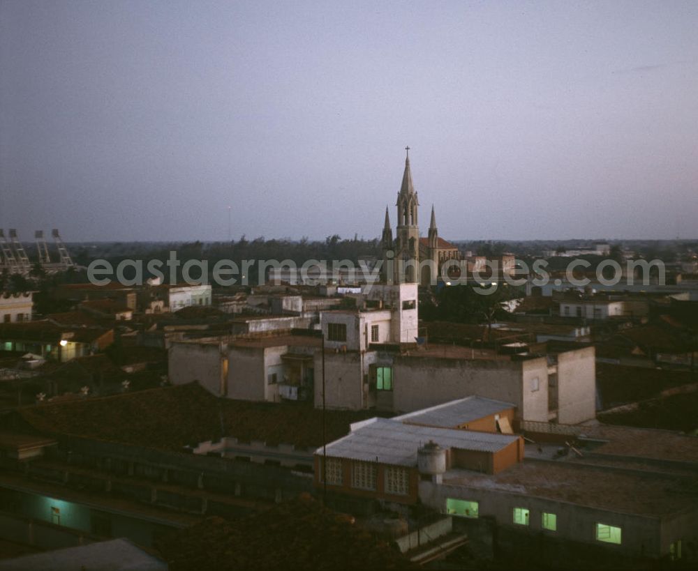 GDR picture archive: Camagüey - Blick über die Dächer der drittgrößten Stadt Kubas, Camagüey, auf die Kirche Iglesia Sagrada Corazon de Jesus. Im Hintergrund das Estadio Cándido González (l).