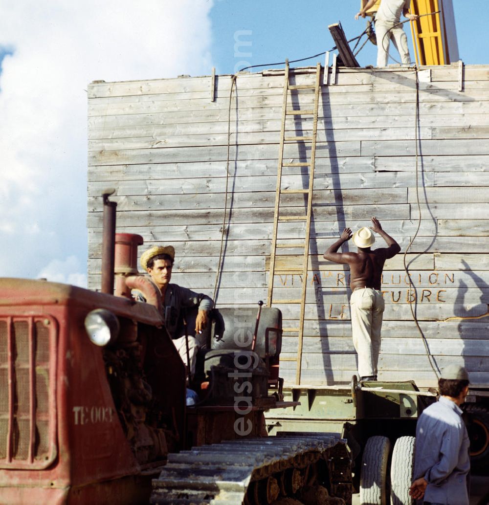 GDR picture archive: Cienfuegos - Arbeiter in einer Düngemittelfabrik in Cienfuegos. An der Bretterwand steht die Aufschrift Viva Revolucion Octubre Lenin. In den 60er und 7