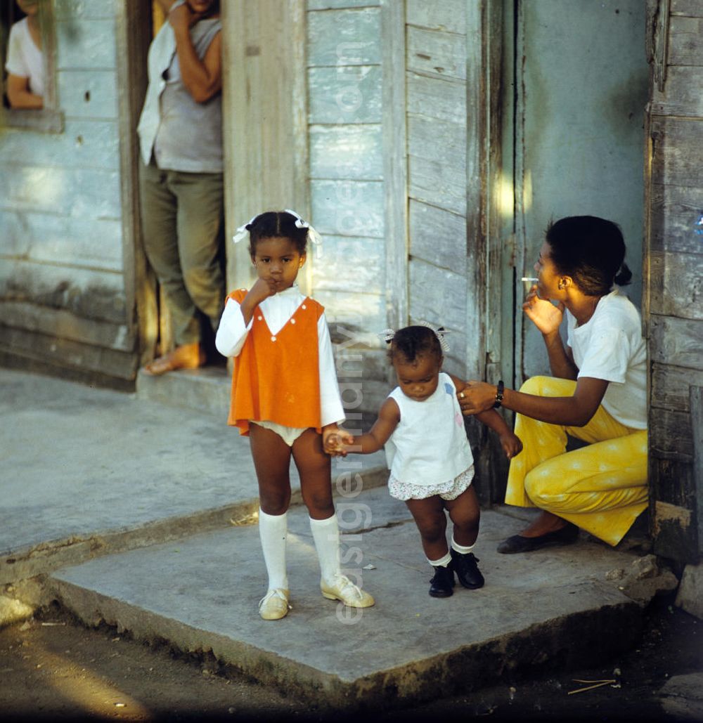Nuevitas: Eine Frau mit ihren zwei Kindern vor dem Eingang ihrer ärmlich wirkenden Behausung in einer Wohnsiedlung in der kubanischen Hafenstadt Nuevitas. Woman with children on the front door.