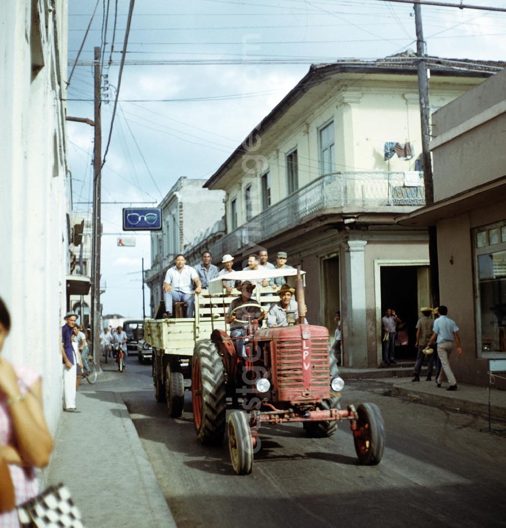 GDR image archive: Santa Clara - Straßenszene in Santa Clara in Kuba - ein Traktor fährt mit Arbeitern zum Ernteeinsatz. Street scene in Santa Clara - Cuba. A tractor drives on the road.