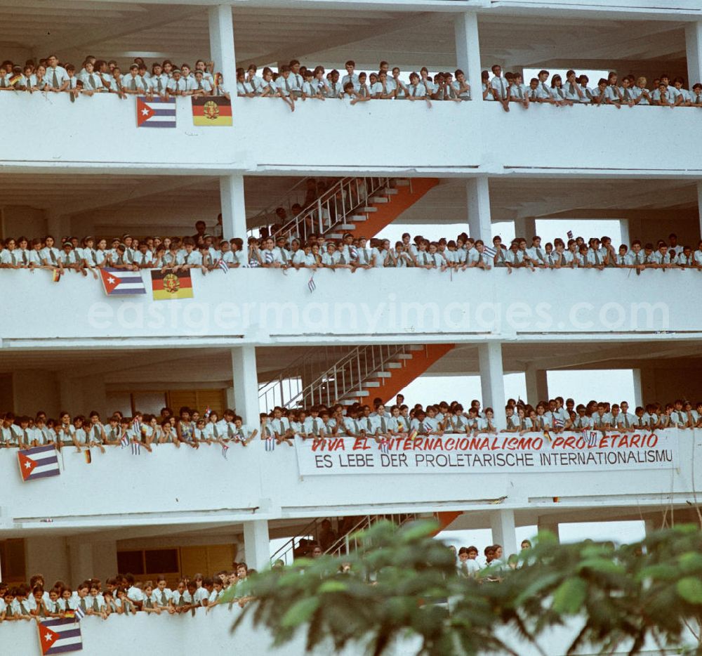 GDR picture archive: Havanna - Mit großem Jubel, DDR-Fähnchen und Willkommens-Plakaten wird in der kubanischen Bevölkerung die Ankunft des Staats- und Parteivorsitzenden der DDR, Erich Honecker, in Havanna gefeiert. Viva el Internacionalismo Proletario - Es lebe der proletarischen Internationalismus steht auf einem der Transparente. Honecker stattete vom 2