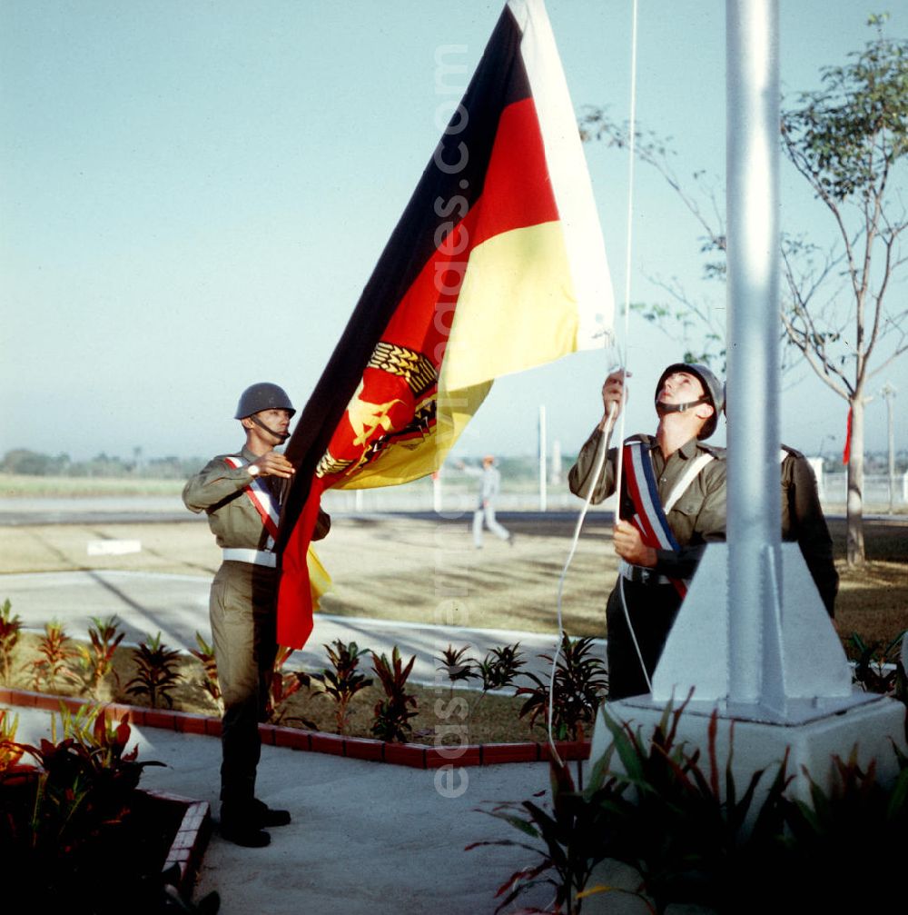 GDR photo archive: Santiago de Cuba - Zum Empfang des Staats- und Parteivorsitzenden der DDR, Erich Honecker, auf dem Flughafen Santiago de Cuba wird von zwei Soldaten die Flagge der DDR gehißt. Honecker stattete vom 2