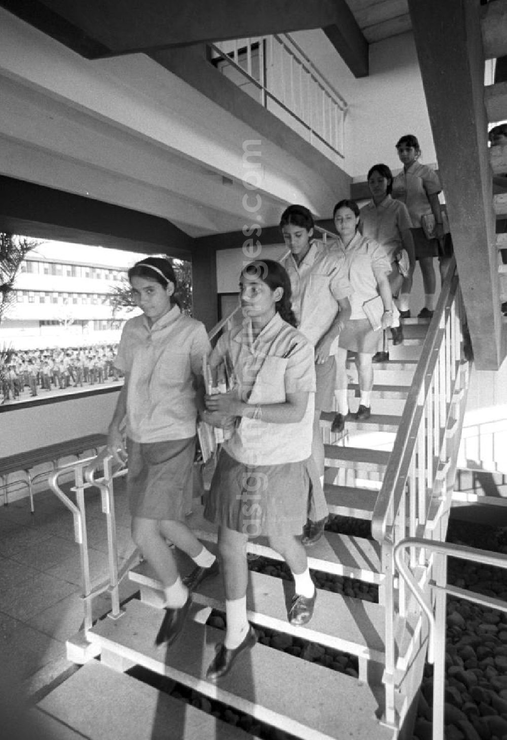 GDR picture archive: Cienfuegos - Schülerinnen der Mittelschule Camilo in Cienfuegos auf dem Weg zum auf dem Schulhof stattfindenden Appell (Hintergrund).