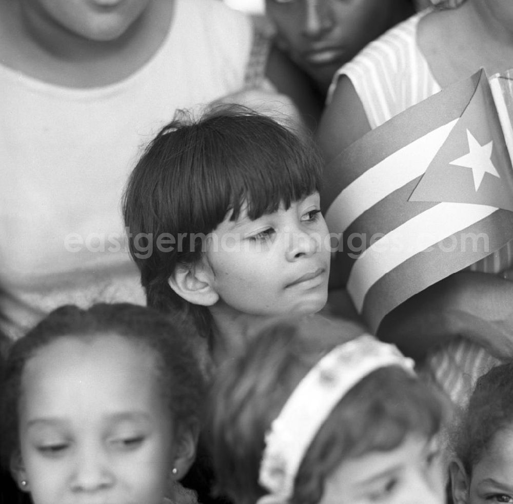 GDR picture archive: Santiago de Cuba - Mit großem Jubel wird in der kubanischen Bevölkerung die Ankunft des Staats- und Parteivorsitzenden der DDR, Erich Honecker, in Santiago de Cuba gefeiert - hier Junge mit Kubafahne. Honecker stattete vom 2