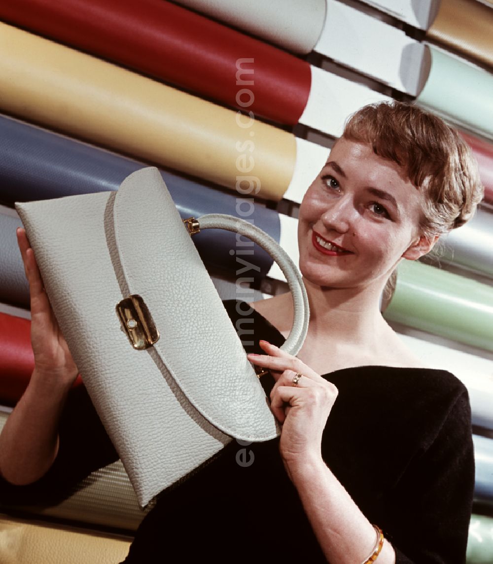 GDR image archive: Coswig - A woman presents a bag made of synthetic leather from VEB Cowaplast-Werke Coswig, Saxony in the territory of the former GDR, German Democratic Republic