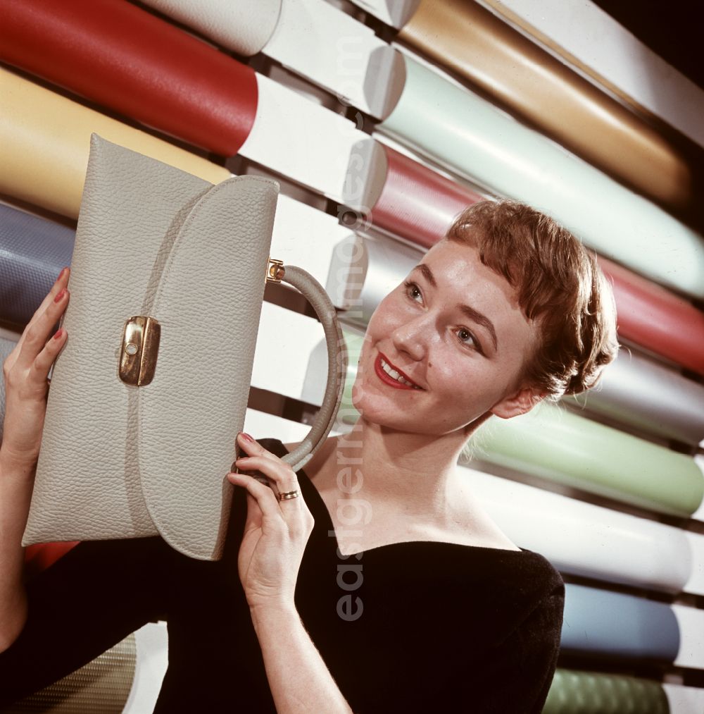 GDR photo archive: Coswig - A woman presents a bag made of synthetic leather from VEB Cowaplast-Werke Coswig, Saxony in the territory of the former GDR, German Democratic Republic