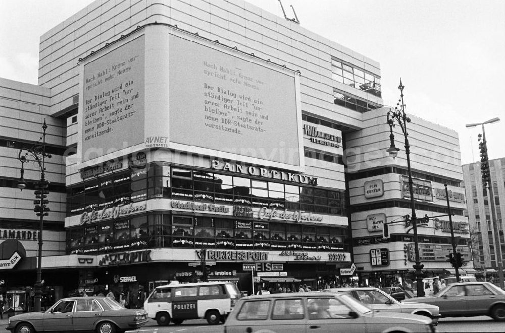 GDR picture archive: Berlin - Blick über die dicht befahrene Einkaufsstraße Kurfürstendamm in West-Berlin. Über eine Videowand werden die Bürger über die Entwicklungen in der DDR informiert.