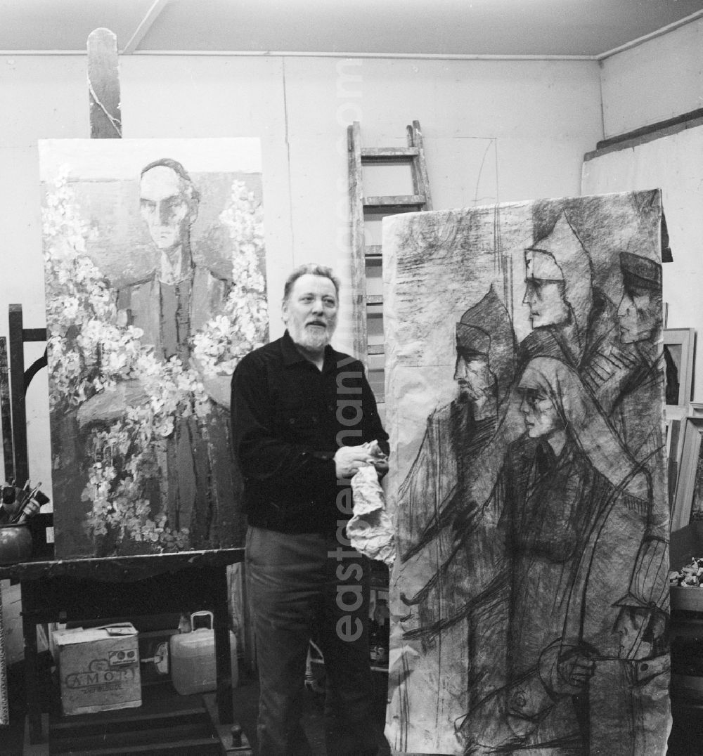 Potsdam: Kurt Hermann Kuehn (1926 - 1989), painter and graphic artist in Potsdam in Brandenburg on the territory of the former GDR, German Democratic Republic. Here in his studio. To his right, a part of the mural The heirs of Spartacus