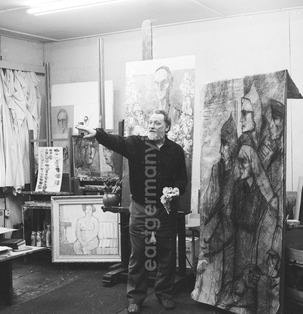GDR photo archive: Potsdam - Kurt Hermann Kuehn (1926 - 1989), painter and graphic artist in Potsdam in Brandenburg on the territory of the former GDR, German Democratic Republic. Here in his studio. To his right, a part of the mural The heirs of Spartacus