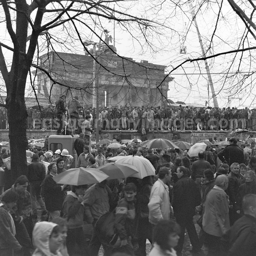 GDR photo archive: Berlin - Happening around the Brandenburg Gate shortly before the opening on the occasion of the Berlin Wall in November 1989 in Berlin. Crowds on and off the Wall at Brandenburg Gate