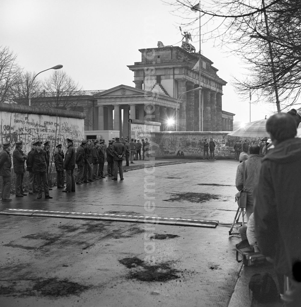Berlin: Happening around the Brandenburg Gate shortly before the opening on the occasion of the Berlin Wall in November 1989 in Berlin. West German FRG and East German GDR border police before an open part of the wall at the Brandenburg Gate