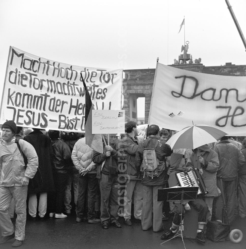 GDR photo archive: Berlin - Happening around the Brandenburg Gate shortly before the opening on the occasion of the Berlin Wall in November 1989 in Berlin. Crowds with bannes before the Wall at Brandenburg Gate