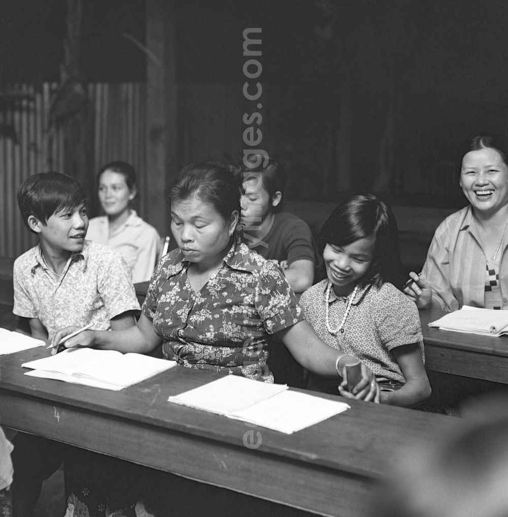 Vientiane: Seite an Seite lernen junge und erwachsene Laoten in einer Schule schreiben und lesen. Nach der Gründung der Volksrepublik Laos im Dezember 1975 wurde das Schulsystem von der neuen kommunistischen Regierung in Laos wieder aufgebaut, um dem in der Bevölkerung weit verbreiteten Analphabetismus entgegenzuwirken.