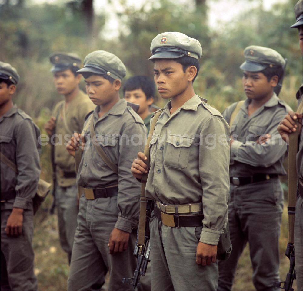 Nam Ngum: Soldaten der laotischen Armee, darunter auch Kinder, in der Demokratischen Volksrepublik Laos. Erst ein Jahr zuvor, am 2. Dezember 1975, war durch die kommunistisch geprägten Kräfte die Volksrepublik Laos ausgerufen worden. Die politische und wirtschaftliche Situation blieb aber auch in den Folgejahren unsicher und instabil. Immer wieder kam es zu Rebellionen aus dem Hinterland, die mit Hilfe der Armee und ausländischer, v.a. vietnamesischer, Unterstützung gewaltsam niedergeschlagen wurden.