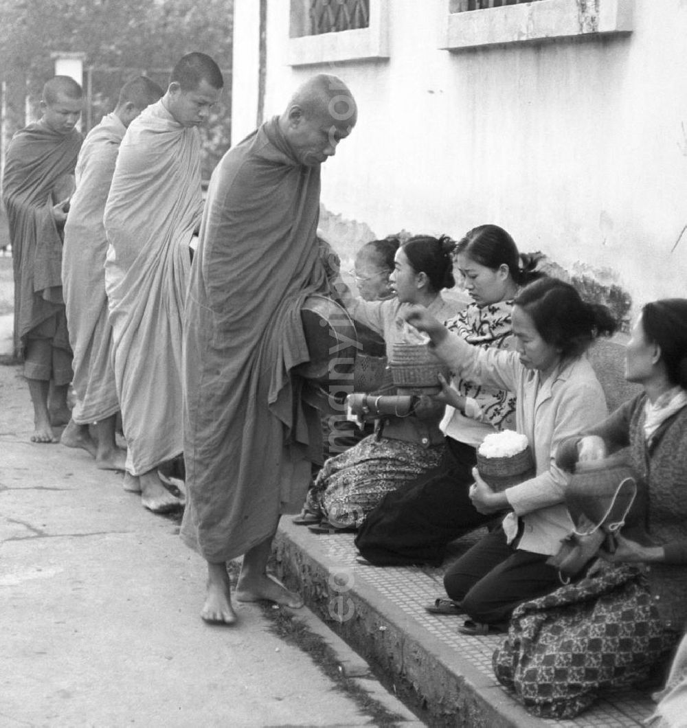 GDR photo archive: Vientiane - Früh am Morgen ziehen Bettelmönche durch Vientiane, der Hauptstadt der Demokratischen Volksrepublik Laos, um sich Essen für den Tag zu erbetteln.