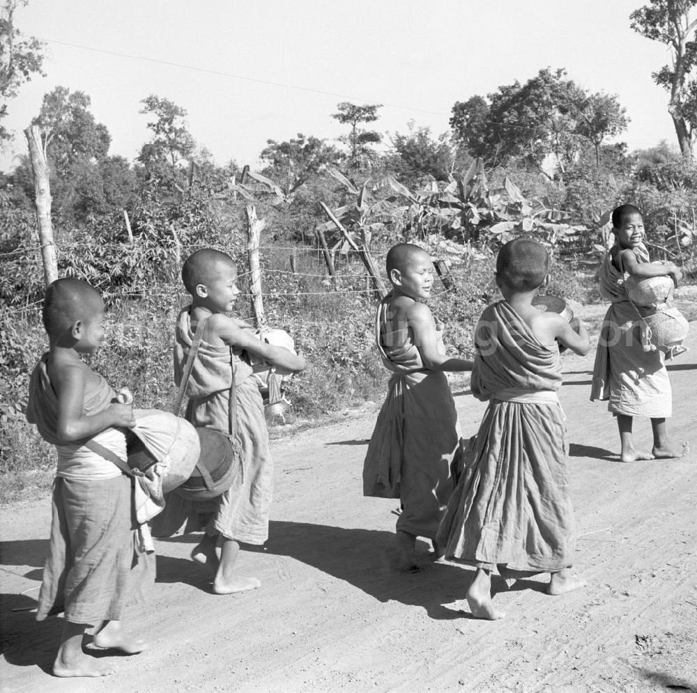 GDR picture archive: Vientiane - Früh am Morgen ziehen kleine Bettelmönche durch Vientiane, der Hauptstadt der Demokratischen Volksrepublik Laos, um sich Essen für den Tag zu erbetteln.