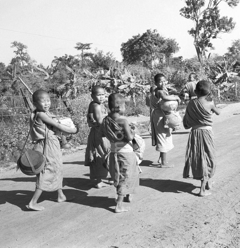 GDR photo archive: Vientiane - Früh am Morgen ziehen kleine Bettelmönche durch Vientiane, der Hauptstadt der Demokratischen Volksrepublik Laos, um sich Essen für den Tag zu erbetteln.
