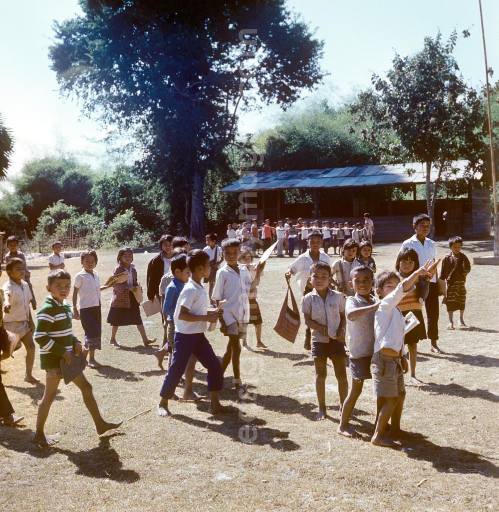 Vientiane: Kinder versammeln sich auf dem Hof einer Schule in einem Dorf in der Demokratischen Volksrepublik Laos. Nach der Gründung der Volksrepublik Laos im Dezember 1975 wurde das Schulsystem von der neuen kommunistischen Regierung in Laos wieder aufgebaut, um dem in der Bevölkerung weit verbreiteten Analphabetismus entgegenzuwirken.