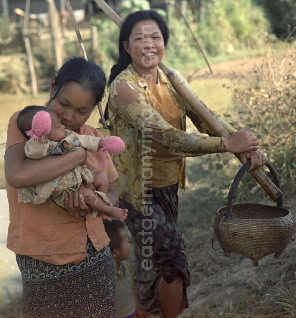 GDR photo archive: Nam Ngum - Eine Frau hält ihr Baby auf dem Arm am Fluß Nam Ngum in der Demokratischen Volksrepublik Laos.