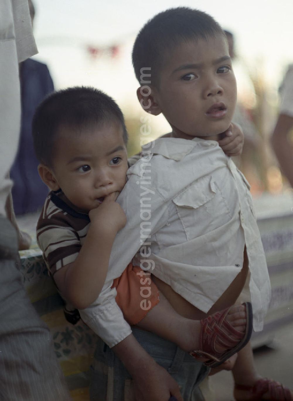GDR photo archive: Vientiane - Ein Junge trägt seinen kleinen Bruder auf dem Rücken in einem Dorf in der Demokratischen Volksrepublik Laos.