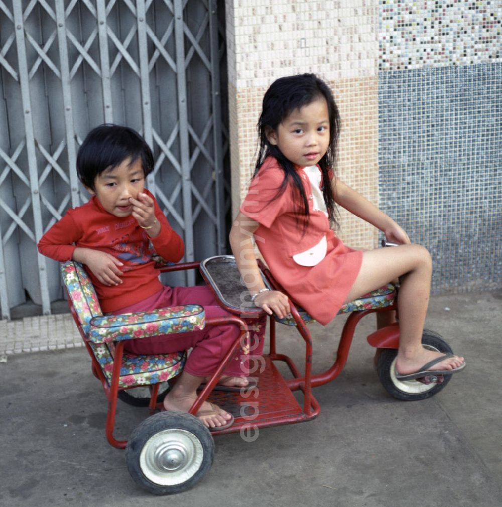 GDR picture archive: Vientiane - Zwei Kinder auf einem Dreirad in Vientiane, der Hauptstadt der Demokratischen Volksrepublik Laos.
