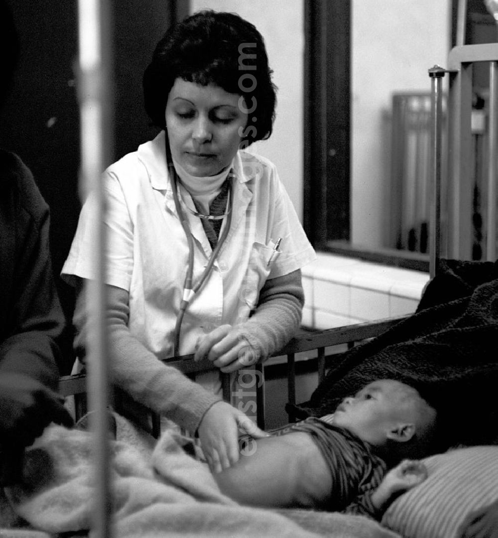 GDR photo archive: Vientiane - Eine kubanische Ärztin untersucht ein laotisches Kind in einem laotischen Krankenhaus in der Demokratischen Volksrepublik Laos.