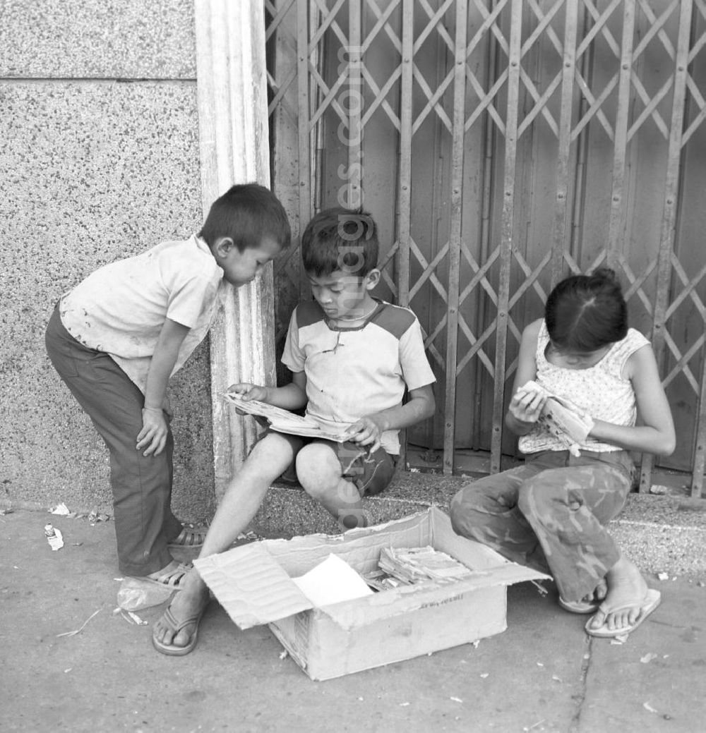 GDR picture archive: Vientiane - Kinder beim Lesen an einer Hauswand in Vientiane in der Demokratischen Volksrepublik Laos.